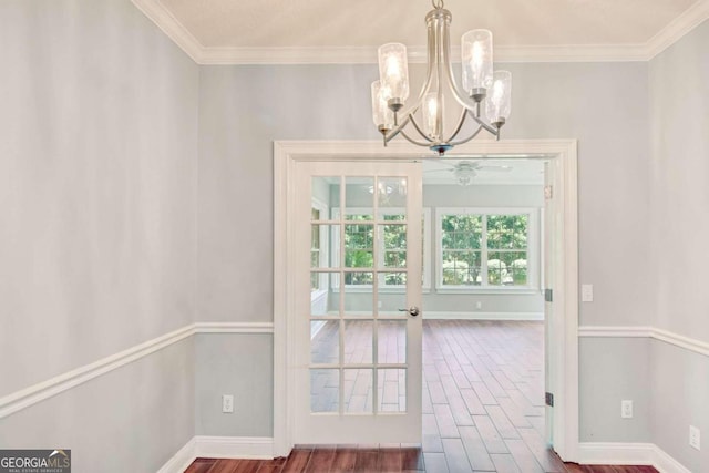 doorway to outside with crown molding, baseboards, and wood finished floors