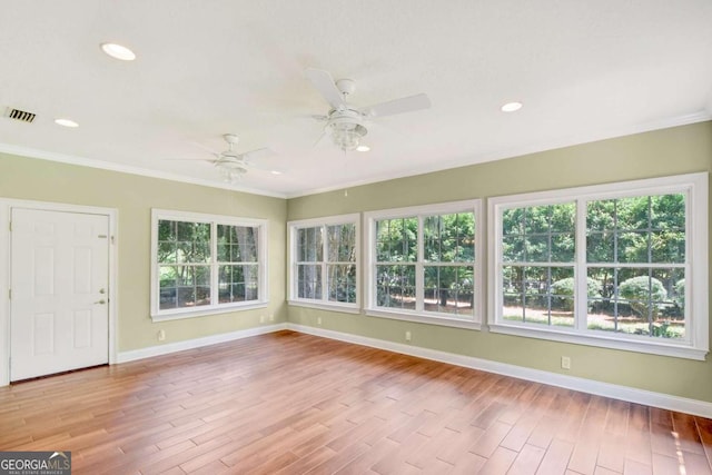 unfurnished sunroom with visible vents and a ceiling fan