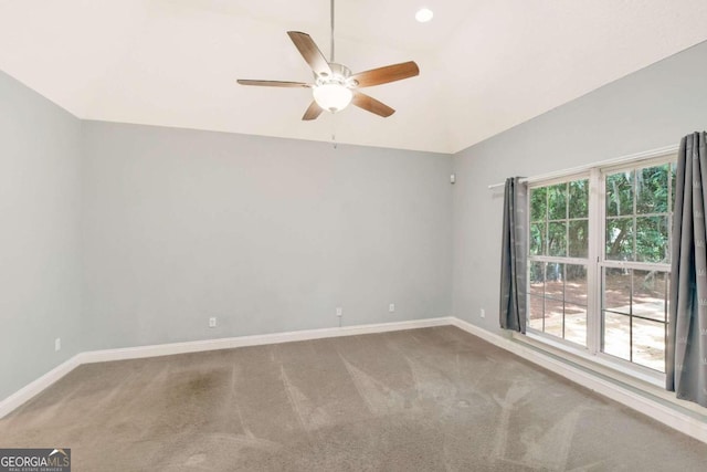 spare room featuring a wealth of natural light, carpet, and vaulted ceiling