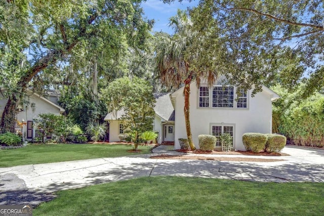 view of front of house with stucco siding and a front yard