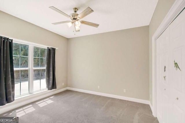 unfurnished room with light colored carpet, ceiling fan, and baseboards