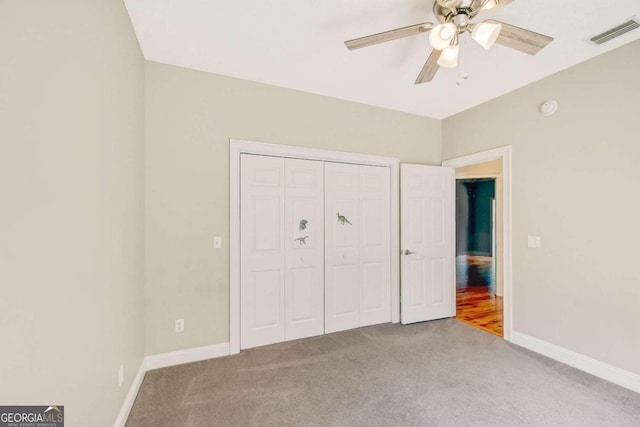 unfurnished bedroom featuring baseboards, visible vents, a ceiling fan, carpet flooring, and a closet