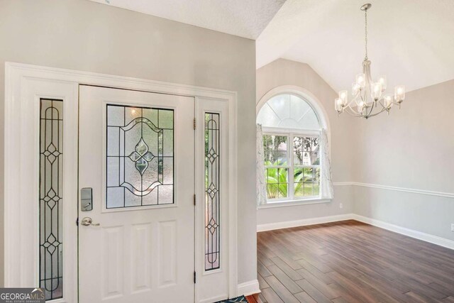 foyer featuring vaulted ceiling, a chandelier, and dark hardwood / wood-style flooring