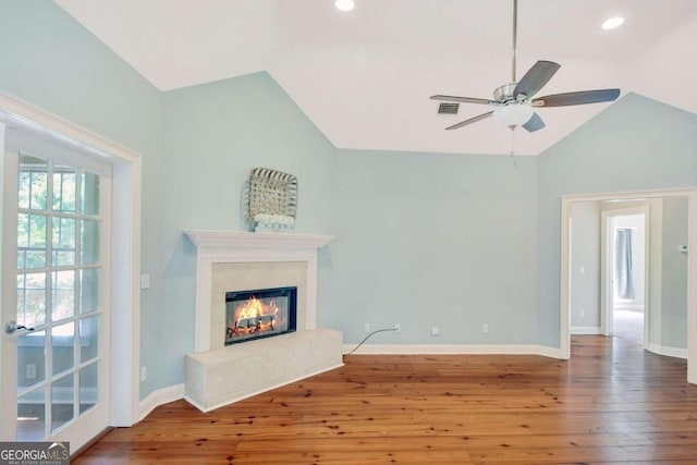 unfurnished living room with lofted ceiling, a fireplace, baseboards, and wood finished floors