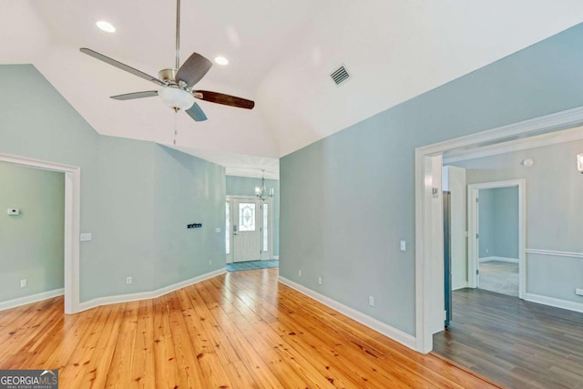 unfurnished room featuring visible vents, vaulted ceiling, baseboards, and wood finished floors