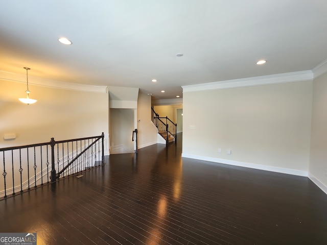 spare room featuring dark hardwood / wood-style floors and crown molding