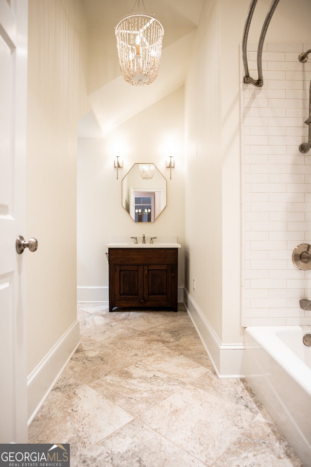 bathroom featuring lofted ceiling, a chandelier, tiled shower / bath combo, and vanity