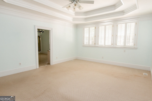 carpeted empty room featuring crown molding, a tray ceiling, and ceiling fan