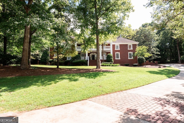 view of front of house with a balcony and a front yard