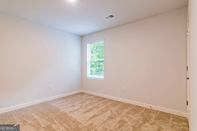 unfurnished room featuring light carpet