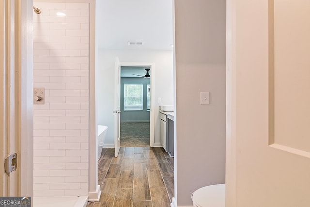 full bathroom featuring independent shower and bath, vanity, hardwood / wood-style floors, and toilet