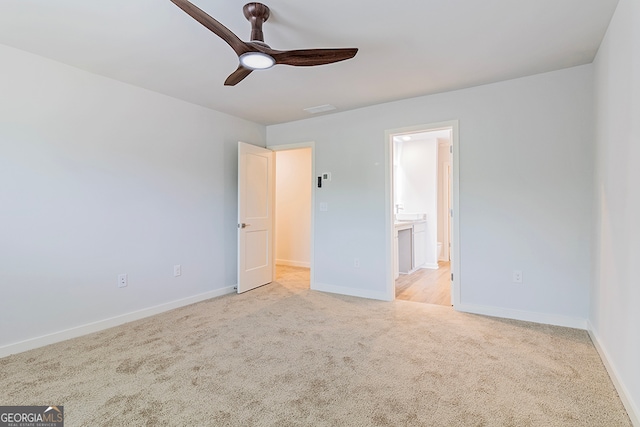 unfurnished bedroom with ceiling fan, light colored carpet, and ensuite bathroom