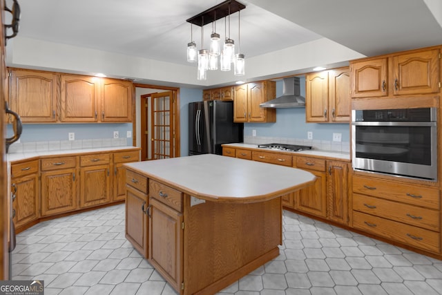 4909 Perry Rd, Claxton, GA 30417 - kitchen featuring stainless steel appliances, wall chimney exhaust hood, light countertops, a center island, and brown cabinetry