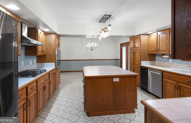 4909 Perry Rd, Claxton, GA 30417 - kitchen featuring stainless steel appliances, wall chimney range hood, a center island, tile counters, and decorative backsplash