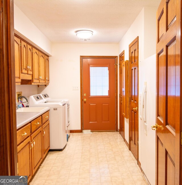 clothes washing area featuring separate washer and dryer, cabinets, and sink