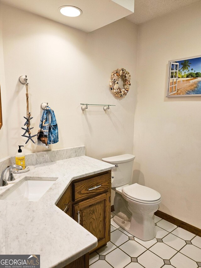 bathroom with vanity, toilet, and tile patterned floors