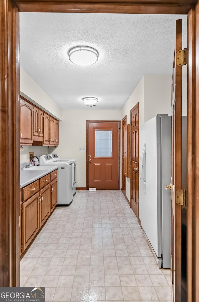 4909 Perry Rd, Claxton, GA 30417 - laundry area featuring cabinet space, washing machine and clothes dryer, and a textured ceiling