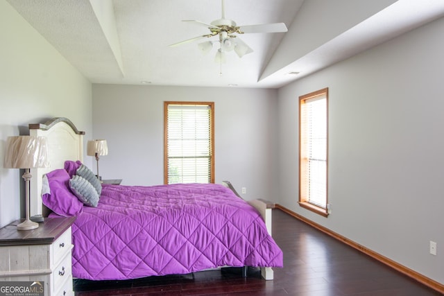 bedroom featuring lofted ceiling, multiple windows, ceiling fan, and dark hardwood / wood-style flooring