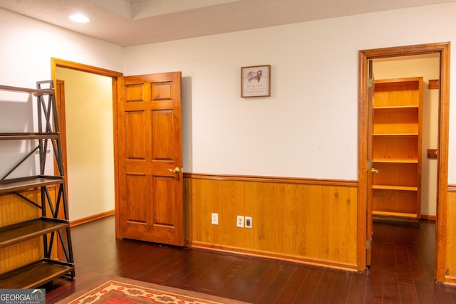 spare room with wooden walls and dark hardwood / wood-style flooring