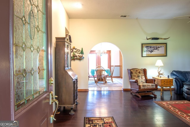 living area with dark wood-type flooring and an inviting chandelier