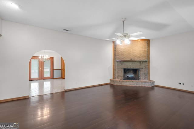 4909 Perry Rd, Claxton, GA 30417 - unfurnished living room with arched walkways, a ceiling fan, a chandelier, a fireplace, and wood finished floors
