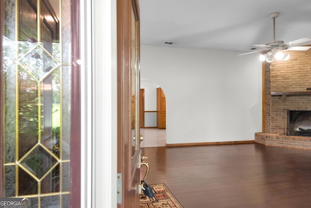 4909 Perry Rd, Claxton, GA 30417 - unfurnished living room featuring ceiling fan, arched walkways, wood finished floors, and healthy amount of natural light