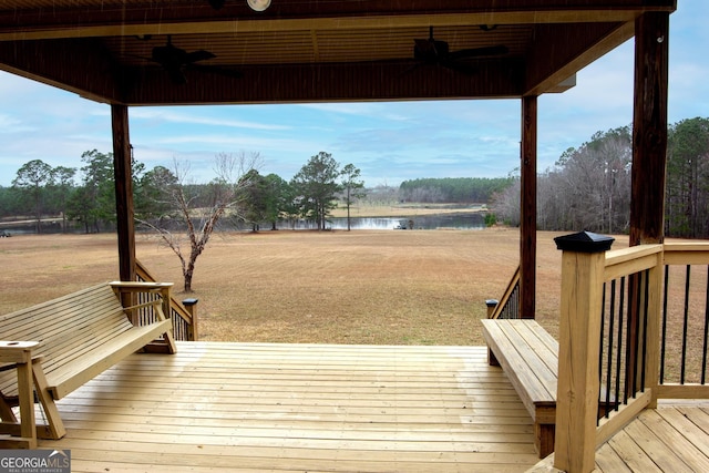 deck with a water view, a lawn, and ceiling fan