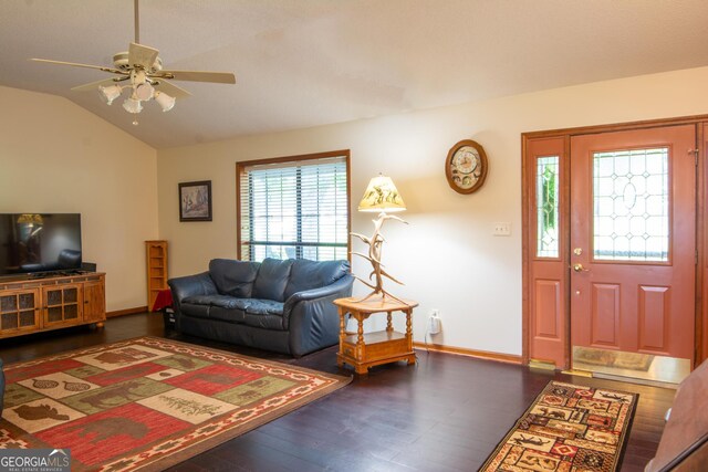 living room with ceiling fan, vaulted ceiling, a fireplace, and dark wood-type flooring