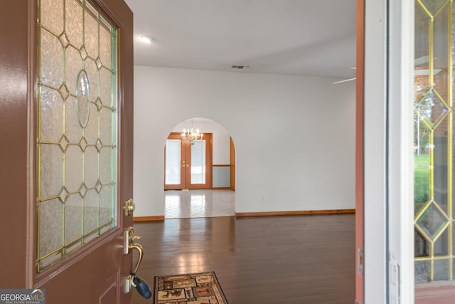 4909 Perry Rd, Claxton, GA 30417 - entryway featuring arched walkways, french doors, a chandelier, and wood finished floors