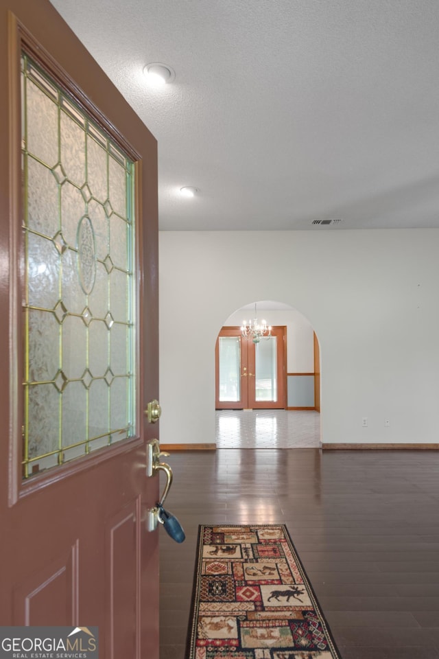 4909 Perry Rd, Claxton, GA 30417 - foyer entrance featuring arched walkways, a chandelier, and wood finished floors