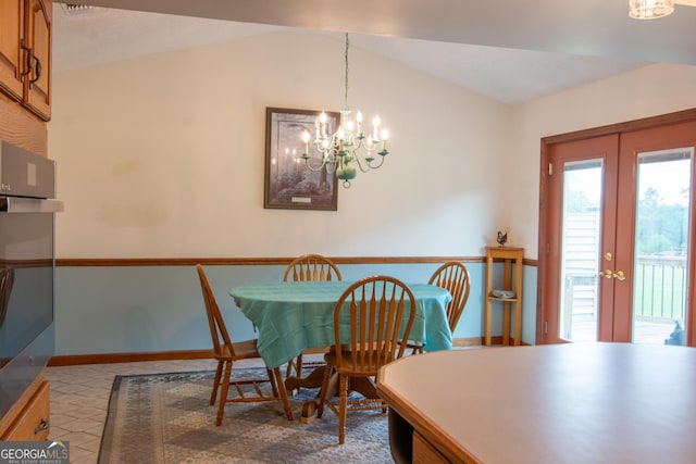 dining room featuring a notable chandelier, light tile patterned floors, vaulted ceiling, and french doors