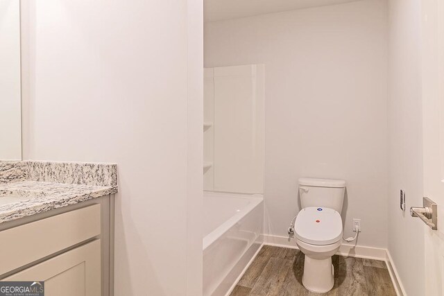 bathroom with wood-type flooring, vanity, and toilet