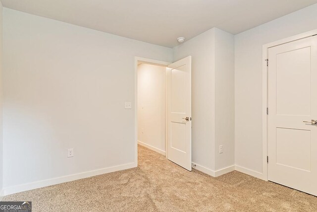 unfurnished bedroom featuring light carpet