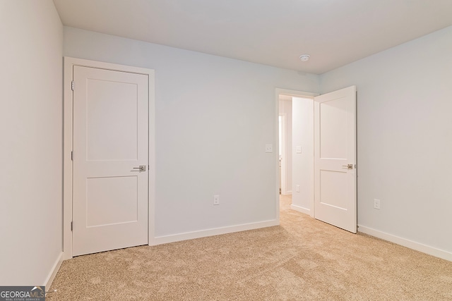 unfurnished bedroom featuring light carpet