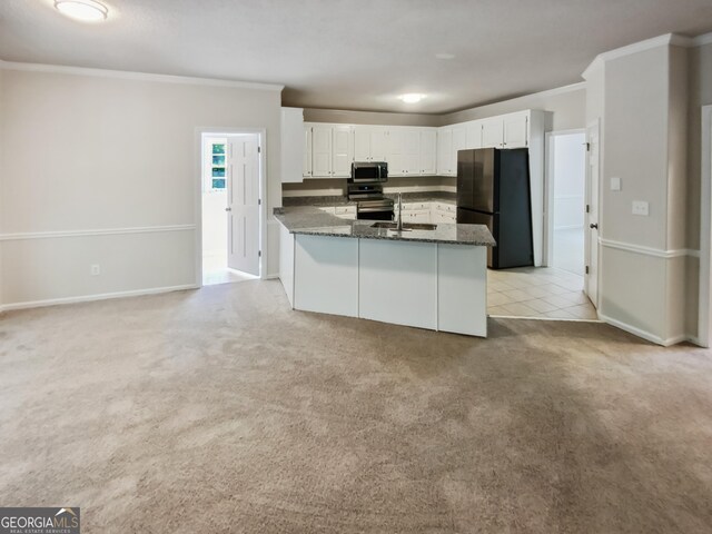 kitchen featuring dark stone countertops, white cabinets, appliances with stainless steel finishes, and light carpet