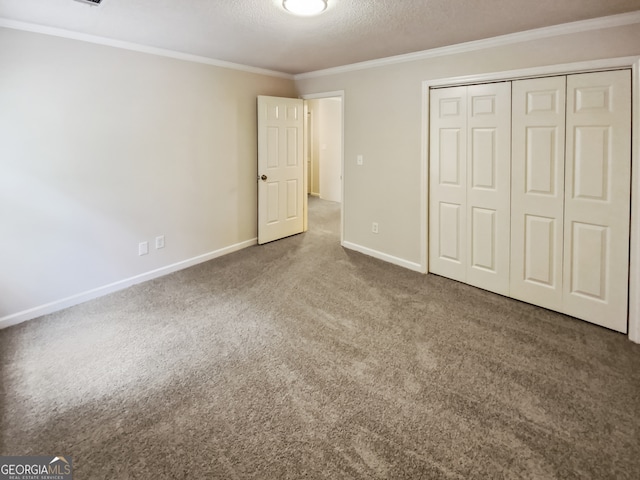 unfurnished bedroom with ornamental molding, a closet, carpet floors, and a textured ceiling