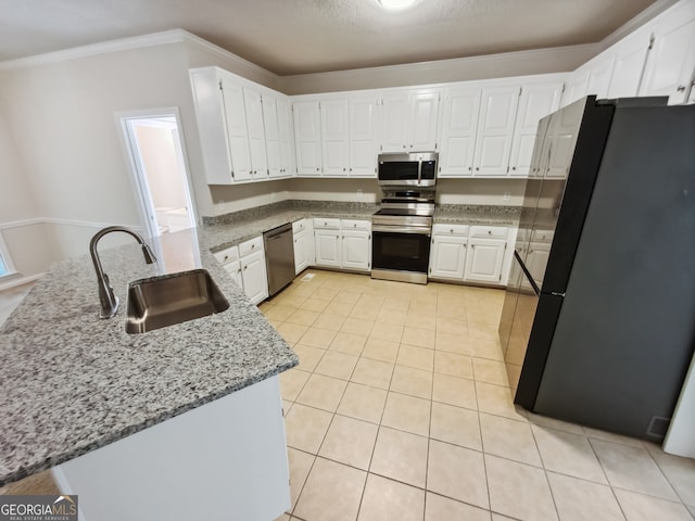 kitchen featuring appliances with stainless steel finishes, light tile patterned flooring, white cabinetry, light stone countertops, and sink