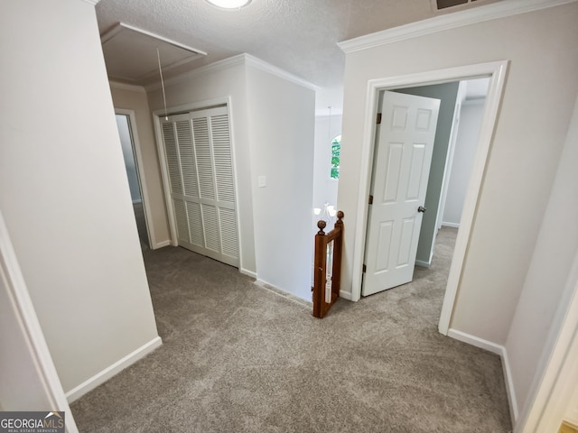 hall with light carpet, a textured ceiling, and ornamental molding