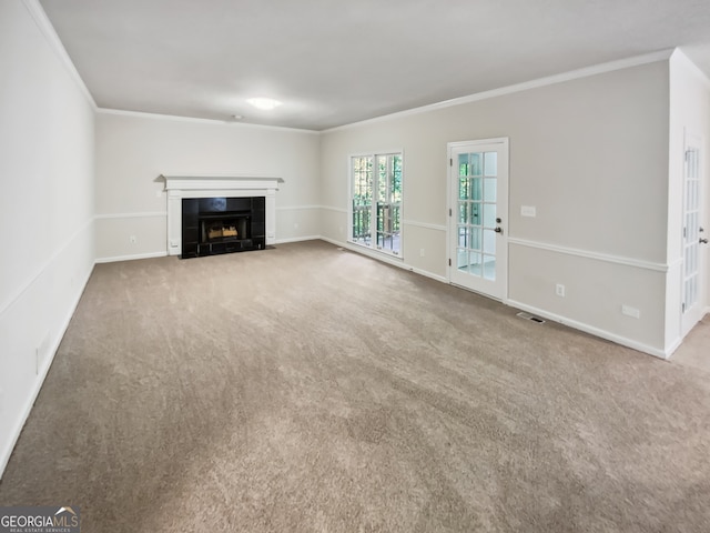 unfurnished living room with ornamental molding, a tiled fireplace, and carpet