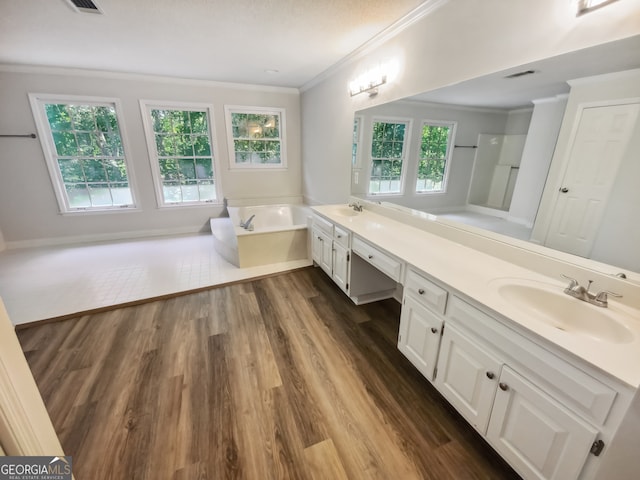 bathroom featuring wood-type flooring, vanity, ornamental molding, and a tub