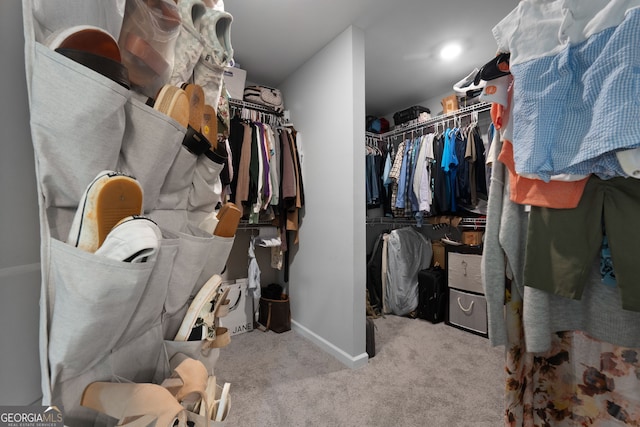 walk in closet with light colored carpet