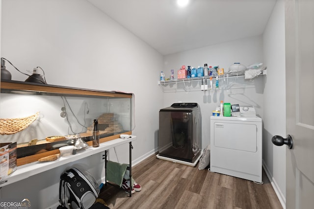 laundry room with wood-type flooring and independent washer and dryer