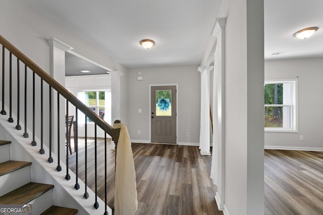 entryway with dark hardwood / wood-style floors and ornate columns