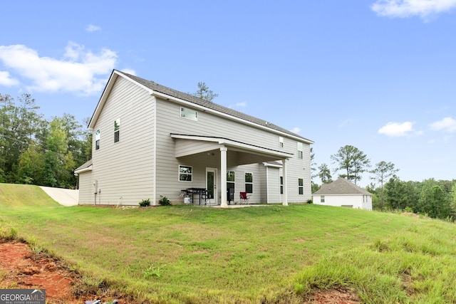 rear view of property with a yard and a patio area