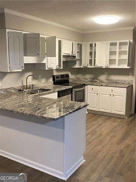 kitchen with dark stone countertops, stainless steel electric stove, a textured ceiling, and white cabinetry