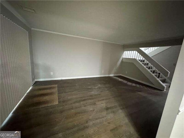 unfurnished living room with ornamental molding and dark wood-type flooring