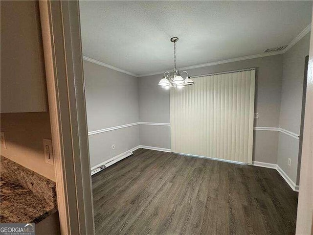 empty room with a baseboard heating unit, a textured ceiling, dark wood-type flooring, a notable chandelier, and ornamental molding