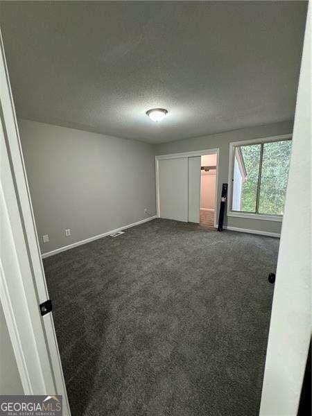 carpeted spare room with a textured ceiling