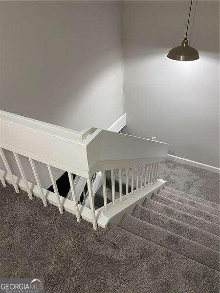 stairway featuring carpet flooring