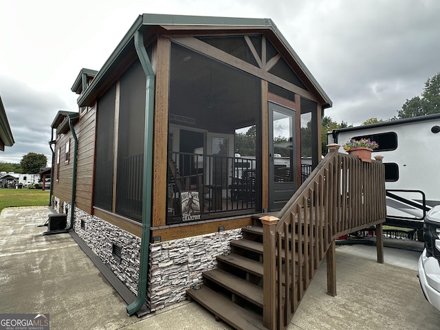 view of side of home featuring a sunroom